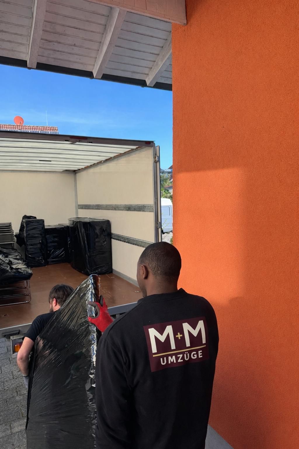 M+M Umzüge Team beim Beladen des Transporters